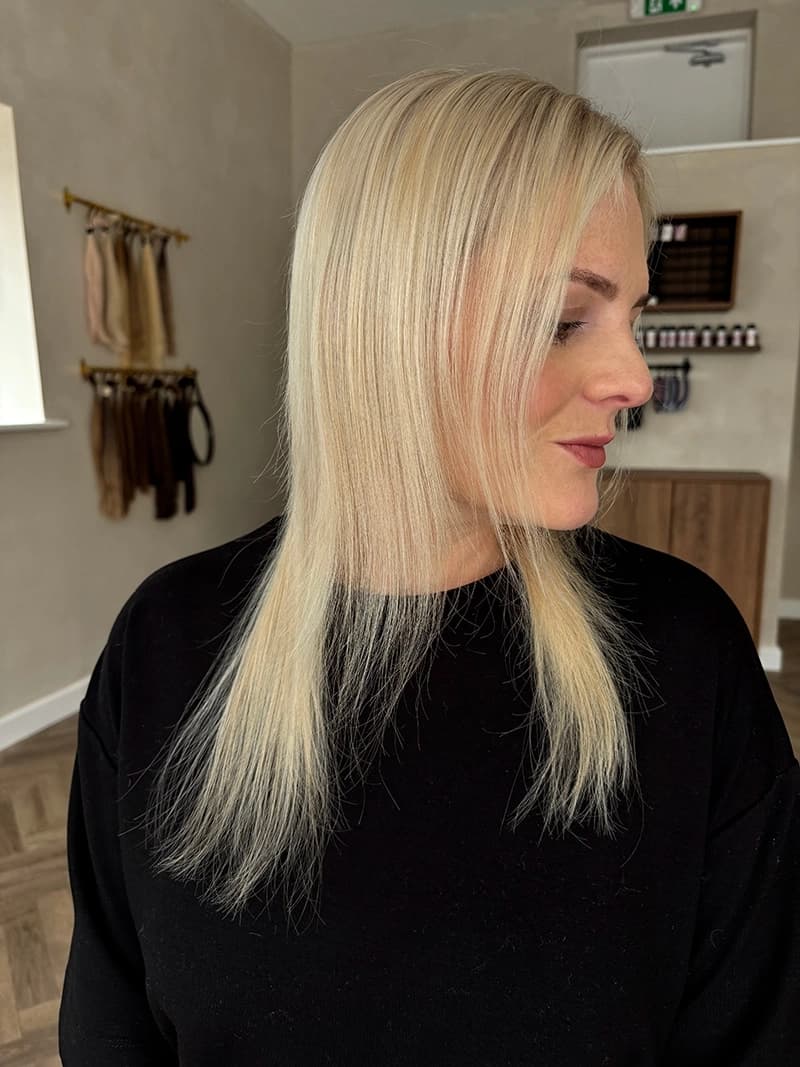 A model with thin hair extensions showing volume transformation
